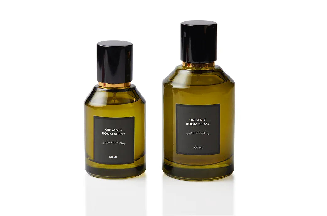 Lemon Eucalyptus botanical body and room mist shown in two olive green glass sizes with sleek black caps. Non-toxic plant-based fragrance handcrafted at our Joo Chiat atelier, combining crisp citrus with camphorous eucalyptus for refreshed breathing space and clean interior air.