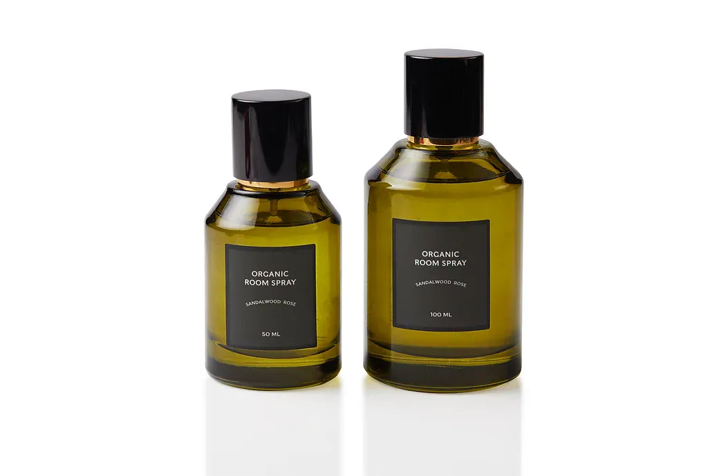 Sandalwood and Rose botanical body and room mist shown in two olive green glass sizes, each finished with a black spray cap. Non-toxic, plant-based natural fragrance handcrafted in Singapore for mindful self-care rituals, refreshed bed linens, and softly luxurious interior atmosphere.