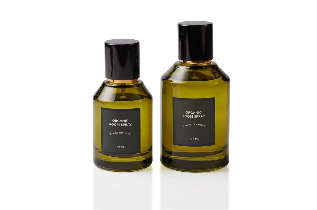 Jasmine, Lily and Neroli botanical body and room mist shown in two olive green glass bottle sizes with sleek black caps. Plant-based, phthalate-free fragrance blended at our Joo Chiat atelier from pure essential oils and absolutes for uplifting white-floral scenting on skin and linens.