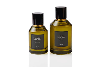 Lemongrass botanical body and room mist presented in two olive green glass bottles with sleek black spray caps. Alcohol-free, plant-based natural fragrance handcrafted at the Artisan of Sense Joo Chiat atelier, offering bright green citrus refreshment for skin, linens, and tropical Singapore interiors.