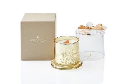 A beautiful gold glass jar holds a hand-poured soy candle with a natural FSC wooden wick, topped with a clear glass dome. The promise of a crackling flame and sustainable presentation makes it a wonderful gift. Scent: Oud . Rose . Amber.