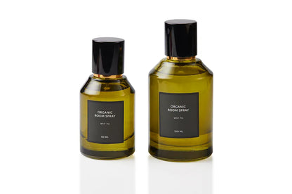 Wild Fig botanical body and room mist presented in two olive green glass bottles with sleek black spray caps. Synthetic-free natural fragrance blended at our Joo Chiat atelier, bringing verdant fig leaf and creamy fruit to daily refresh rituals and relaxed interior styling.